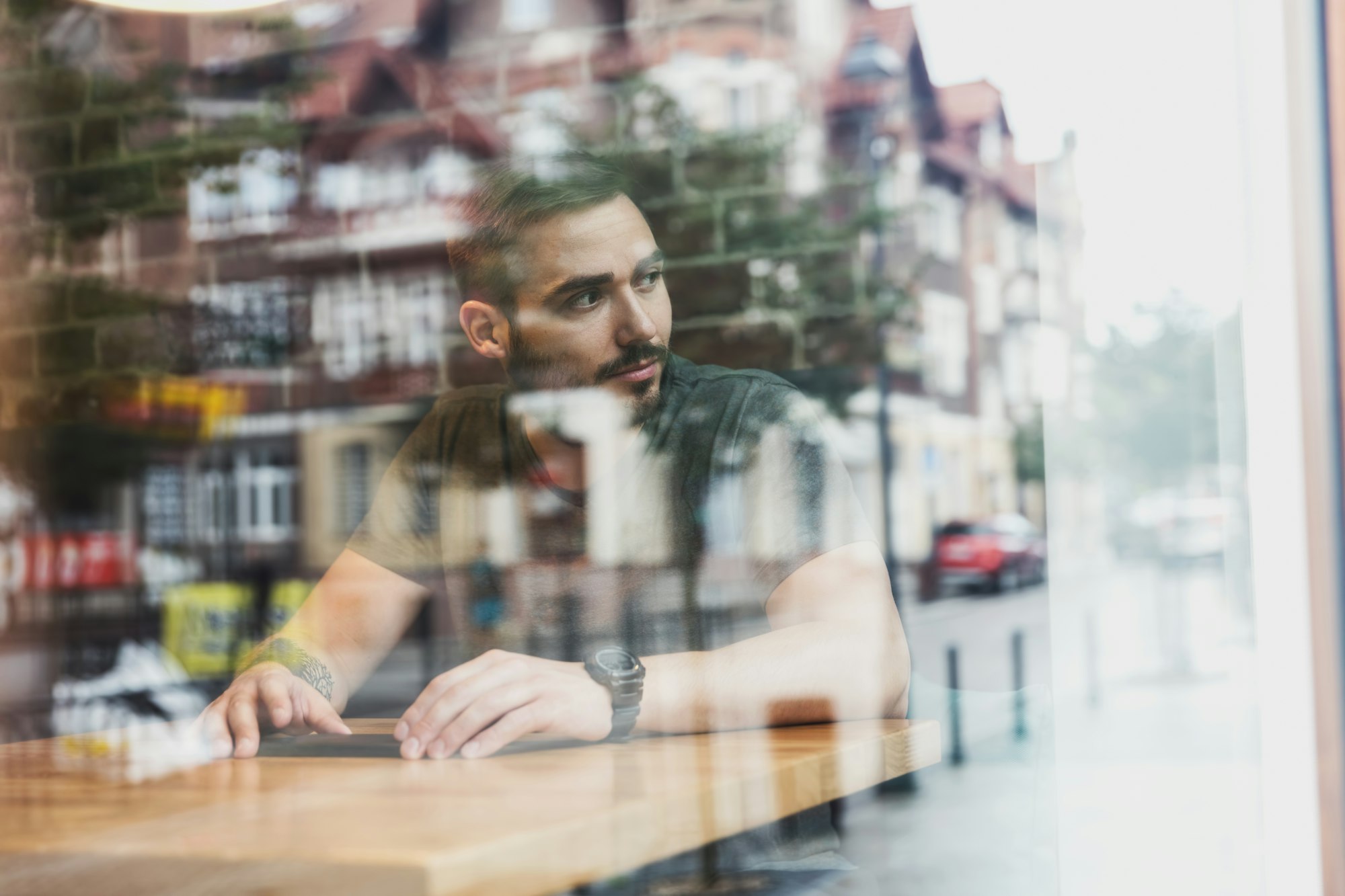 Man in a cafe reflecting in glass. City life