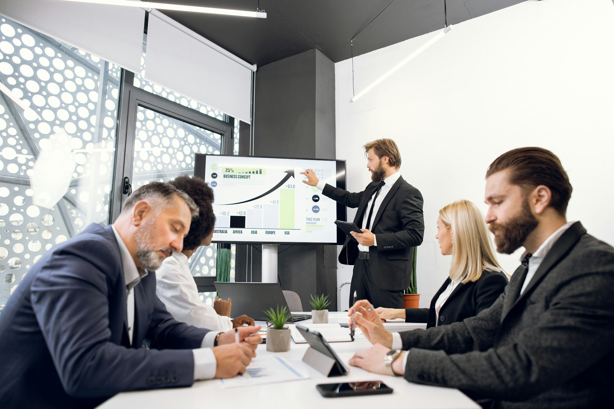 Business concept. Handsome bearded male team leader having a presentation on digital whiteboard