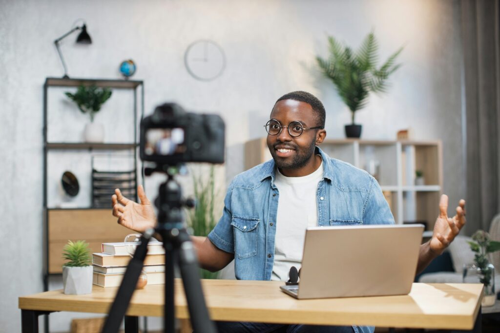 Freelancer using laptop and camera for recording video