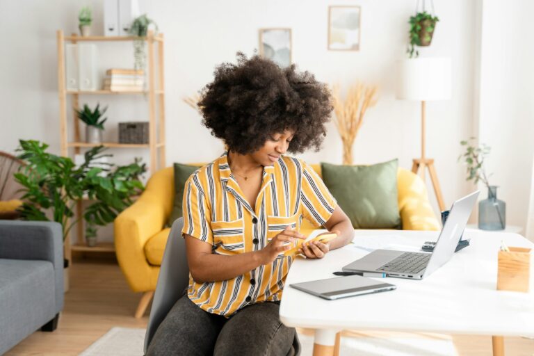 Smiling black woman working on laptop