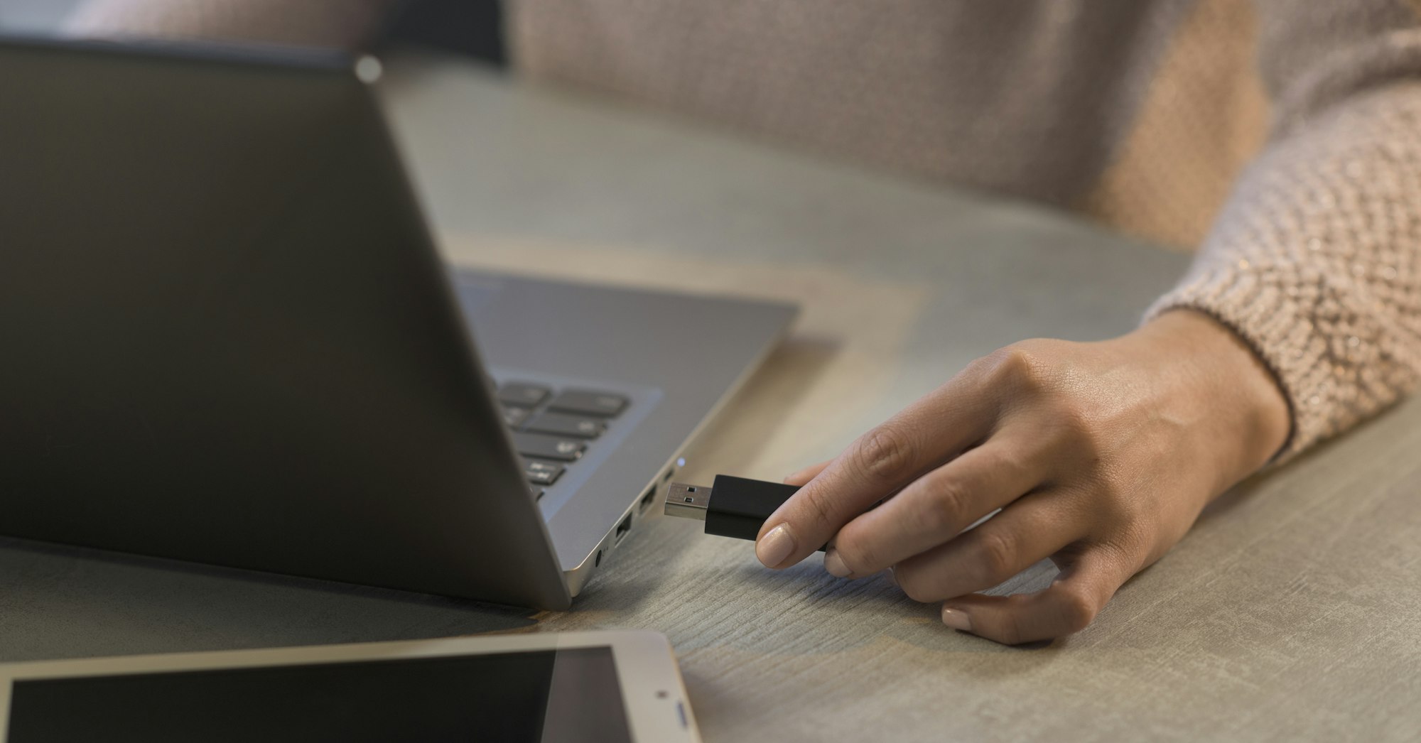 Woman plugging a USB flash drive into her laptop