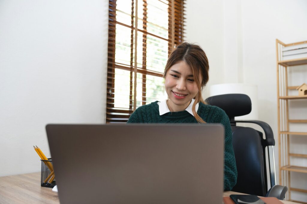 Young smart businesswoman working at home office using laptop having online video meeting with