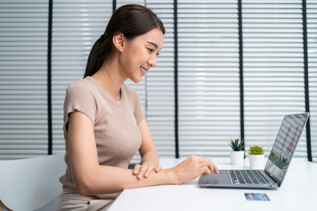 Asian young woman use laptop computer for shopping product sell online.