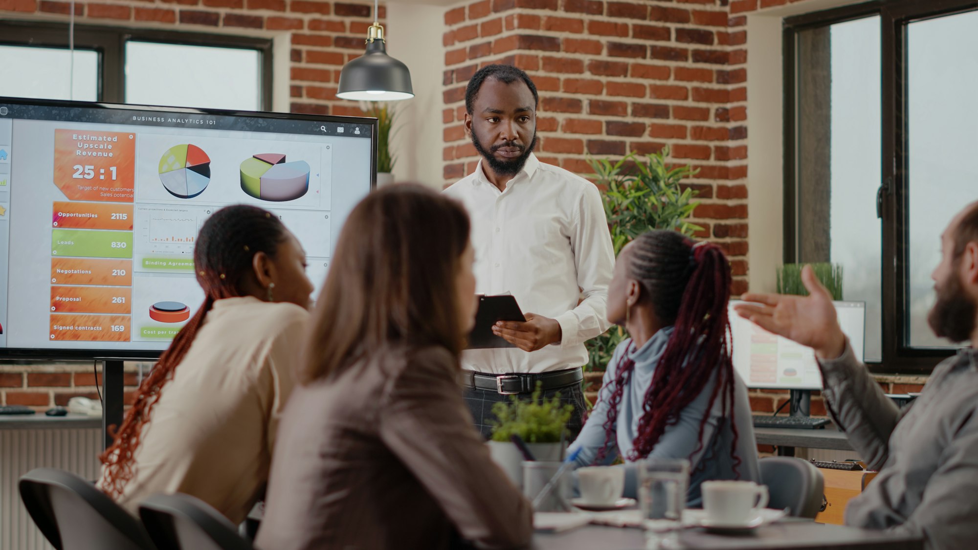 Company employee explaining charts presentation on monitor