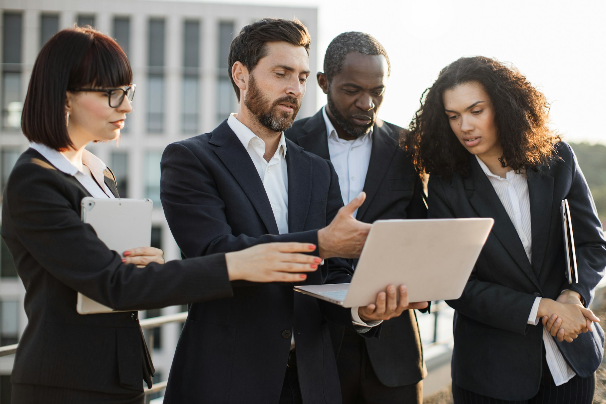 Diverse sales managers watching online presentation outdoors