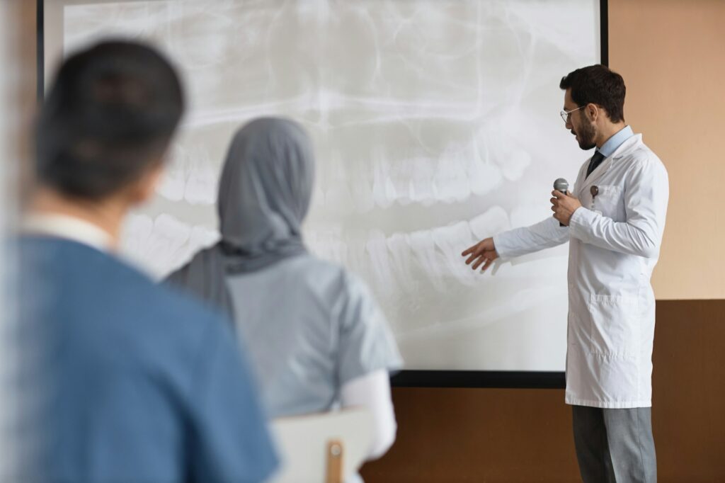 Male Dentist Holding Medical Presentation with Projection Screen