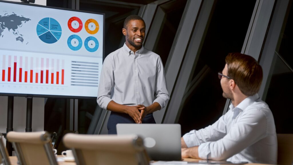 Young analyst telling colleague using tv multimedia