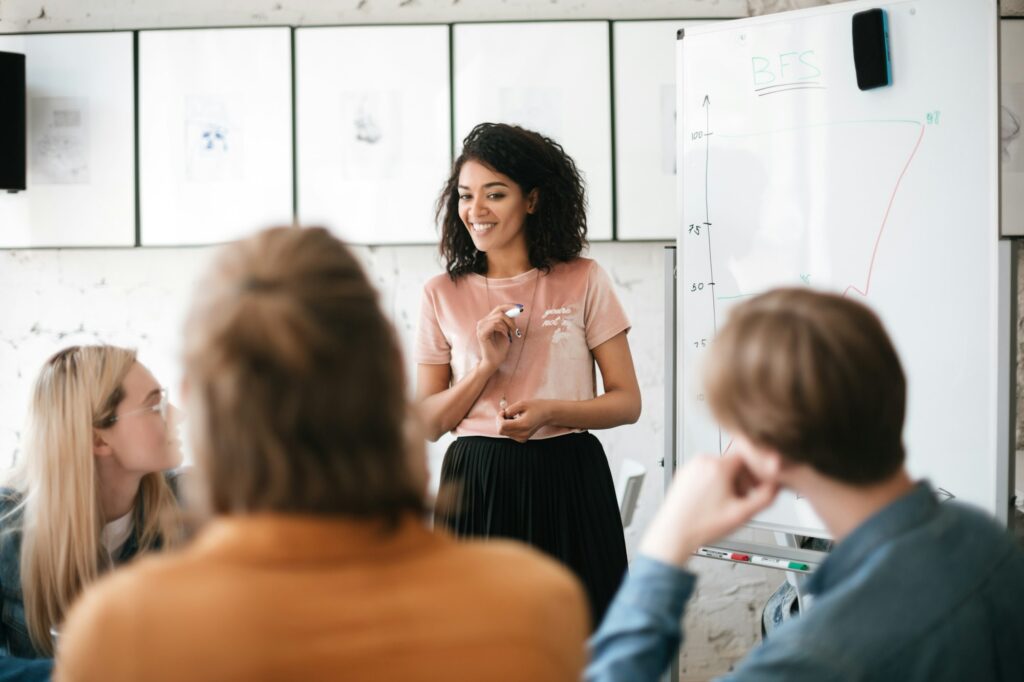 Young beautiful business woman giving presentation to coworkers