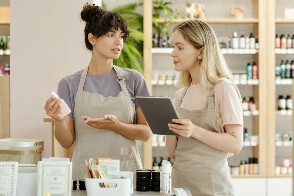 Young brunette female shop assistant making presentation of new product