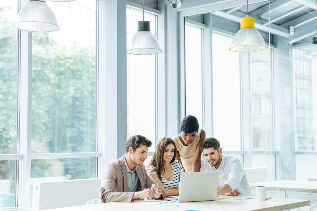 Business people creating presentation and using laptop together in office