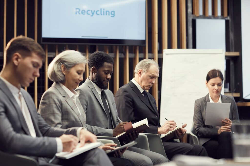 Business people making notes at lecture