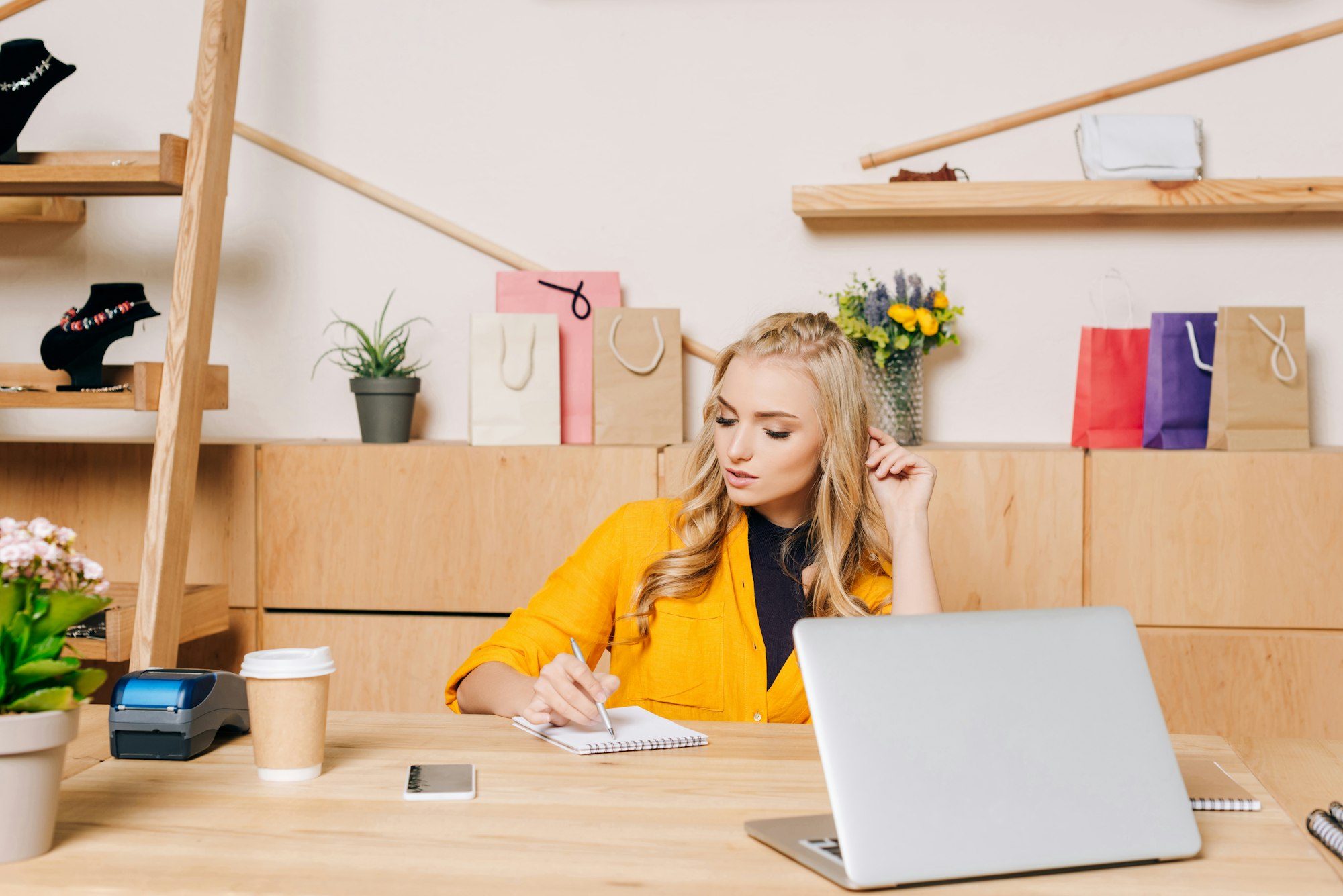 clothing store manager writing notes at workplace