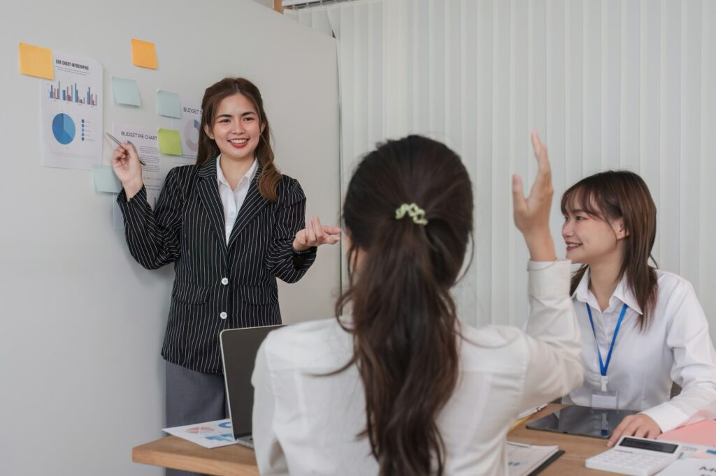 Female Operations Manager Holds Meeting Presentation for a Team of Economists. Asian Woman Uses