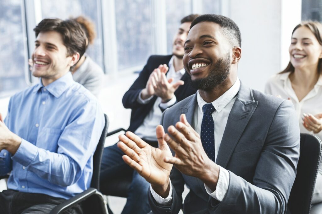 Happy businessmen applauding good presentation in office