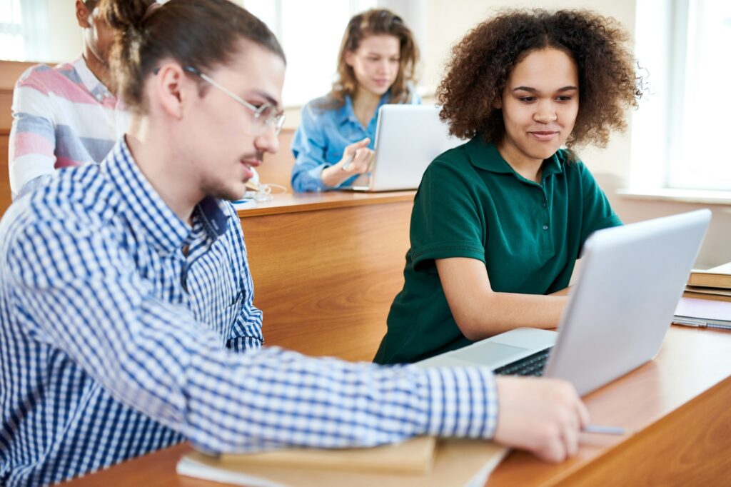 Positive student team discussing presentation at university clas