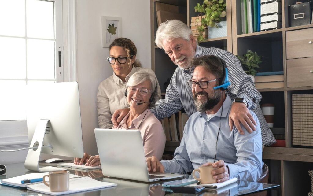 Teamwork of business women and men working together with computer and laptop