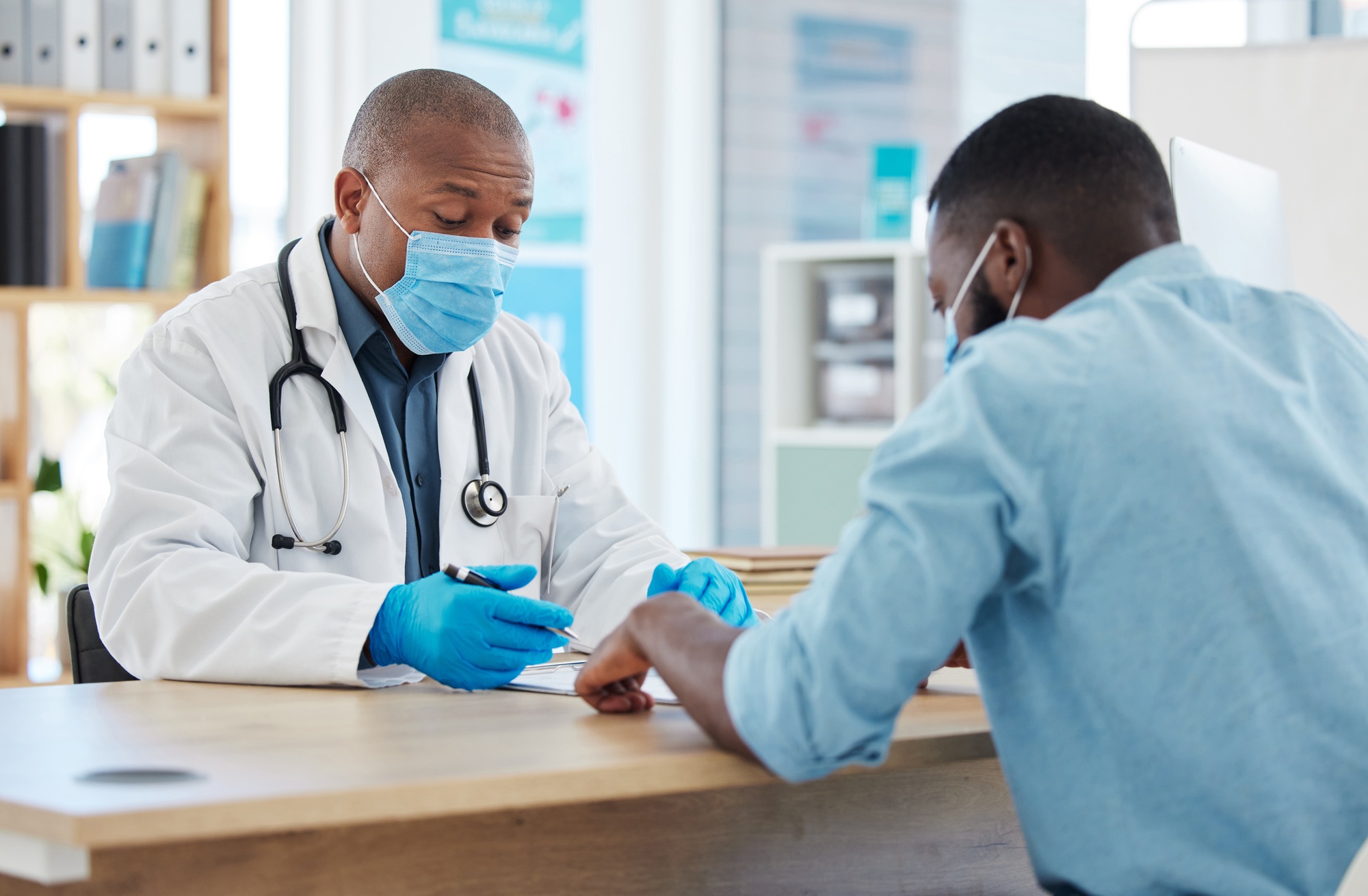 African american doctor talking to a patient in a consult. Doctor and patient talking about their c